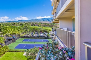 Ein Tennisplatz mit Blick auf eine gebirgige Landschaft.