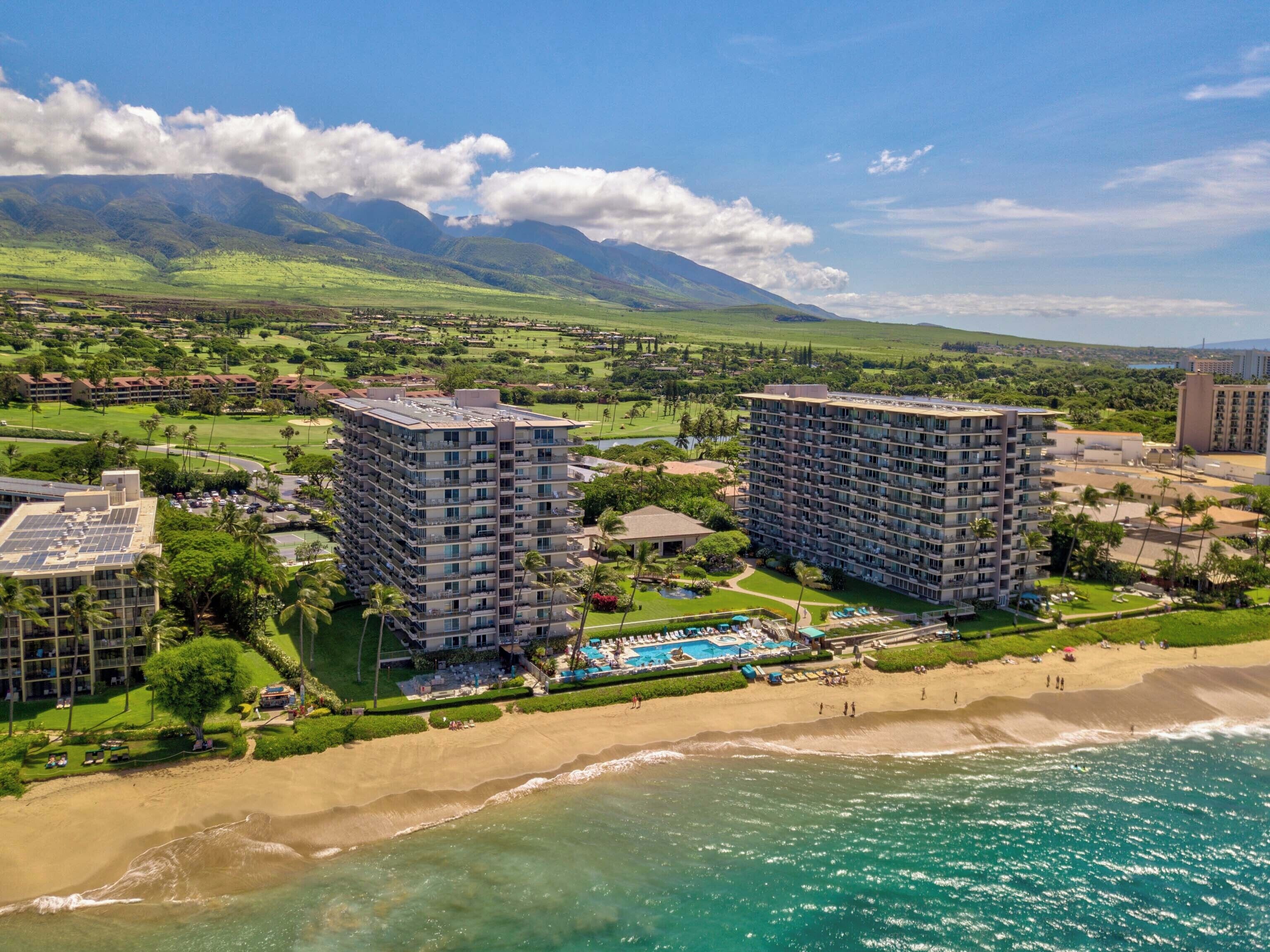 Un resort con dos edificios de gran altura, una playa y una zona de piscina.