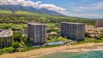 Un resort con dos edificios de gran altura, una playa y una zona de piscina.