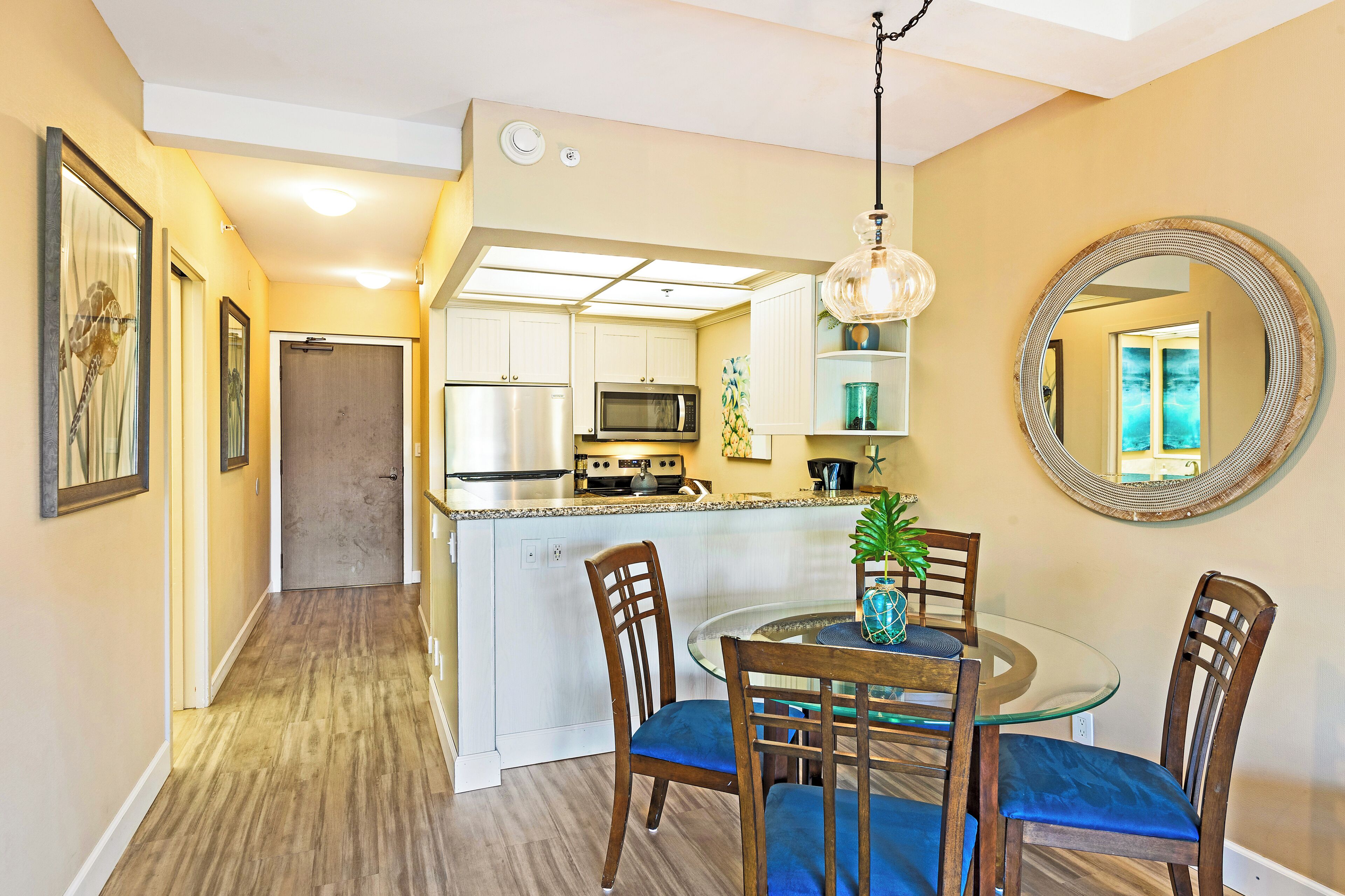 A modern kitchen with white cabinets, a microwave, and a stainless steel refrigerator.