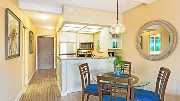 A modern kitchen with white cabinets, a microwave, and a stainless steel refrigerator.
