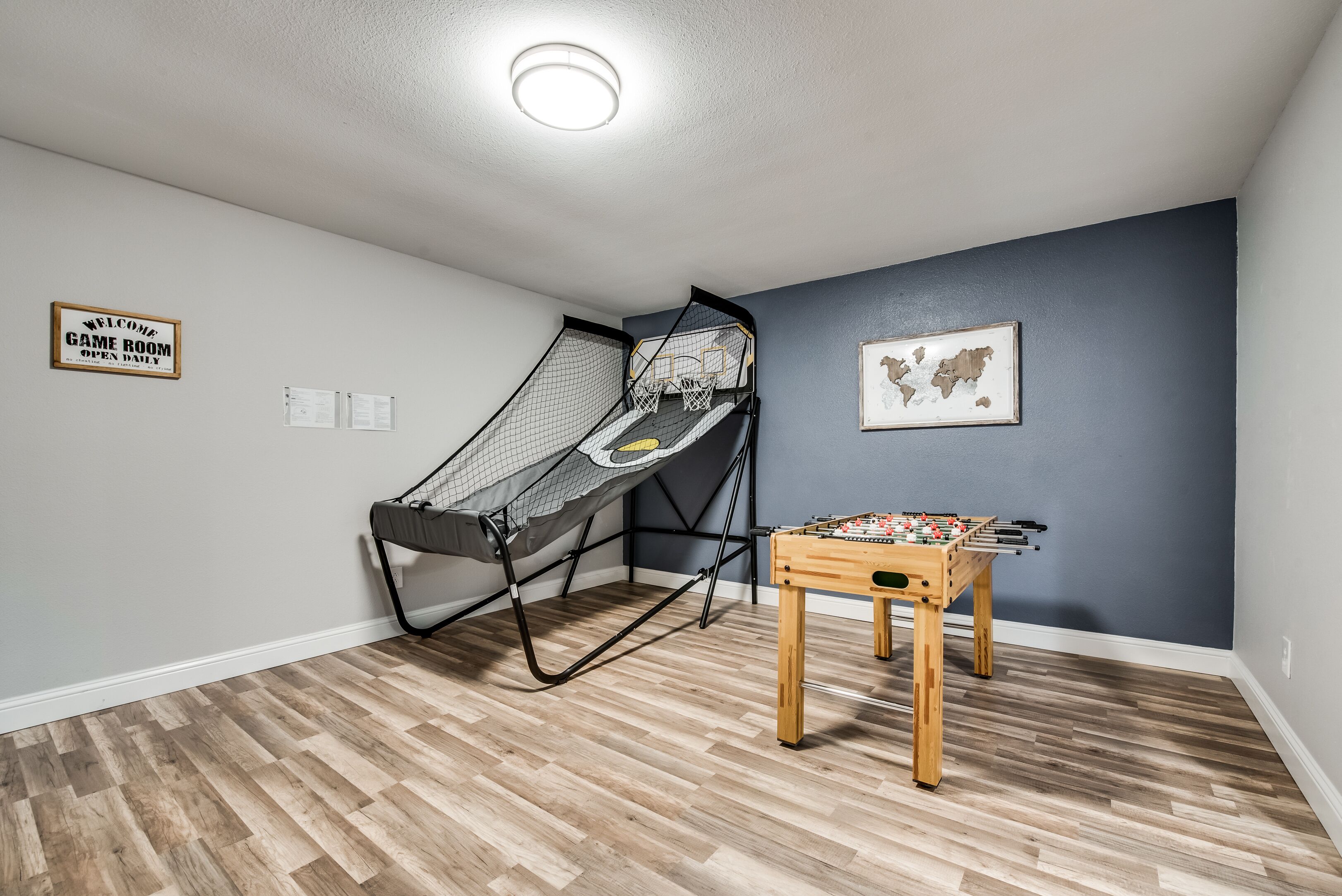 A room with a futsal table and a netted play area.