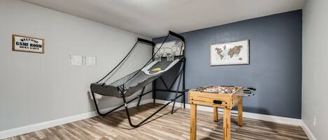 A room with a futsal table and a netted play area.