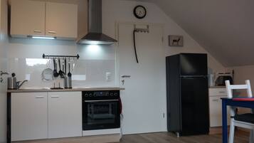 Een koelkast, een oven, een kookplaat, een koffiezetapparaat/waterkoker