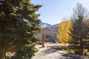A parking area with a stop sign, a mountain in the background, and autumn-colored trees. - Beaver Creek West S2 2 Condo by RedAwning (Avon)
