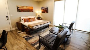 A bedroom with a bed, a desk, a chair, and a large window. - Sage Creek E3 *Pet Ok* Pvt Hot Tub * Heated Pools (Moab)