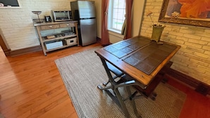 A compact kitchen with a refrigerator, toaster, and a small dining table.