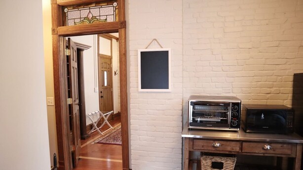 A kitchen with a wooden cabinet, a microwave, and a toaster.