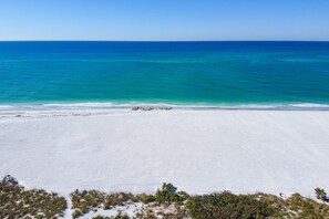 Ein Strand mit weißem Sand und blauem, klaren Meer.