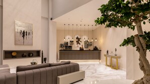 Un interior moderno con un sofá modular, una zona de bar y un árbol grande.