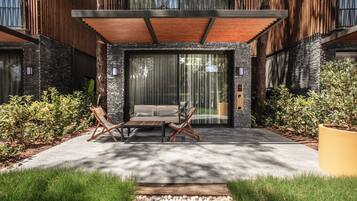 Une maison moderne dotée d’un patio, d’un espace salon extérieur et d’une grande fenêtre.