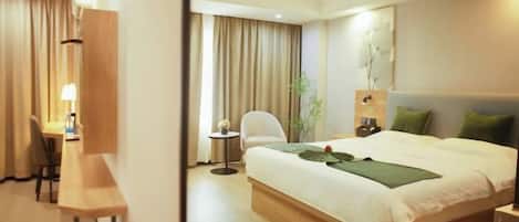 A hotel room with a bed, a desk, a chair, a small table, and a nightstand.