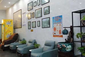 A lobby with framed pictures on the wall, a reception desk, and seating area with chairs. - GreenTree Inn Express Hotel (Haikou Haixiu Middle Road Bangbaihui City Branch) (Haikou)