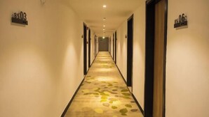 A hotel hallway with a carpet featuring a leaf pattern, doors numbered 8503 and 8506, and a ceiling light fixture. - GreenTree Inn Express Hotel (Haikou Haixiu Middle Road Bangbaihui City Branch) (Haikou)