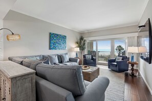 A modern living room with a grey sofa, a coffee table, and a TV.