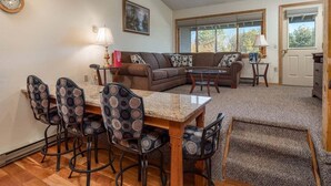 A living room with a dining area, a sofa set, a coffee table, and a fireplace.
