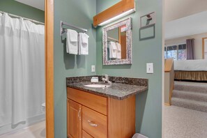 A bathroom with a sink, mirror, and towel rack.