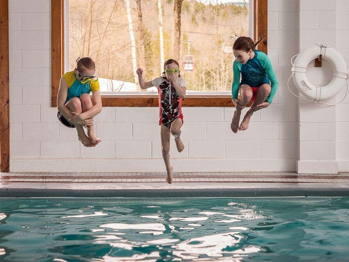 Ein Hallenbad mit Sprungbrett und Rettungsboje an der Wand.