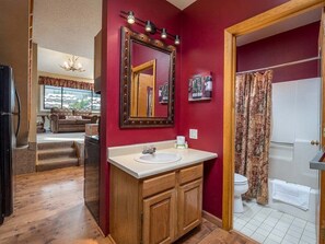 Un baño con tocador, espejo y cortina de ducha.