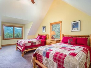 A bedroom with two beds, a window, a lamp, and a framed picture on the wall. - Peaks Hideaway at Sunday River (Newry)