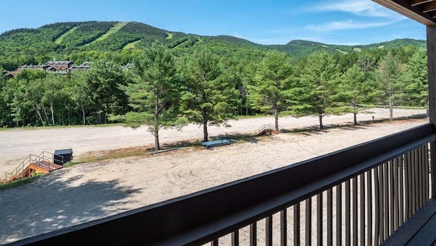 A covered outdoor area with a view of a forested hillside. - Sunday River Condo: Brookside I B-306 (Newry)