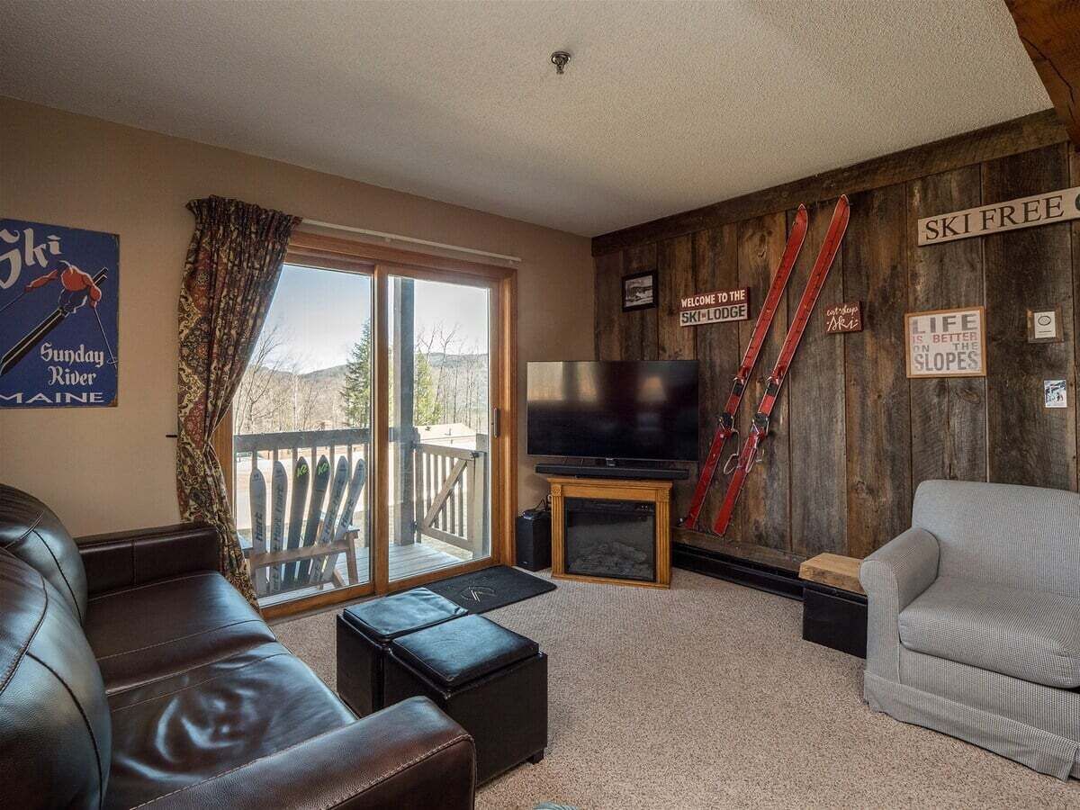 Ein gemütliches Wohnzimmer mit Fernseher, Ledersofa und Kamin.