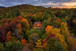 A lodge surrounded by autumn foliage with a clear view of the landscape.