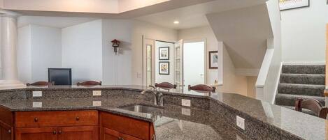 A kitchen with granite countertops, wooden cabinets, and a built-in stove.