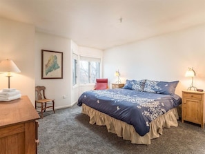 A bedroom with a bed, a chair, a desk, a lamp, and a window. - Locke Mountain J-3 - Sunday River Townhouse (Newry)