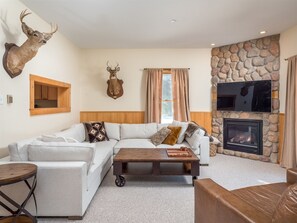 Relax in this stylish living room with a sofa, coffee table, and stone fireplace.