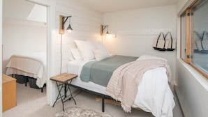 A bedroom with a bed, bedside table, lamp, and window. - Brookside II B-107 - Sunday River Slopeside Condominium (Newry)