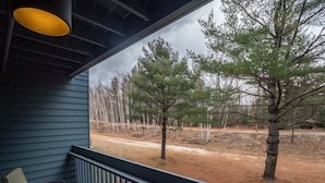 A porch with a view of trees and a dirt path. - Brookside II B-107 - Sunday River Slopeside Condominium (Newry)