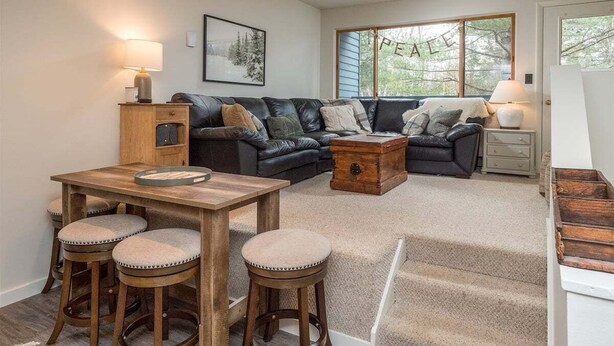 A cozy living room with a wooden table, two sofas, and a coffee table. - Brookside II B-107 - Sunday River Slopeside Condominium (Newry)