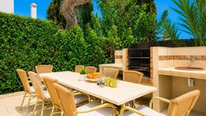 An outdoor dining area with a table and chairs, a grill, and a sink. - Villa Binimelis - Five Bedroom Villa, Sleeps 10 (Cala d'Or)