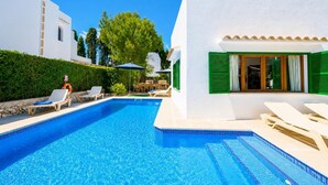 A swimming pool with lounge chairs and a building with green shutters. - Villa Binimelis - Five Bedroom Villa, Sleeps 10 (Cala d'Or)