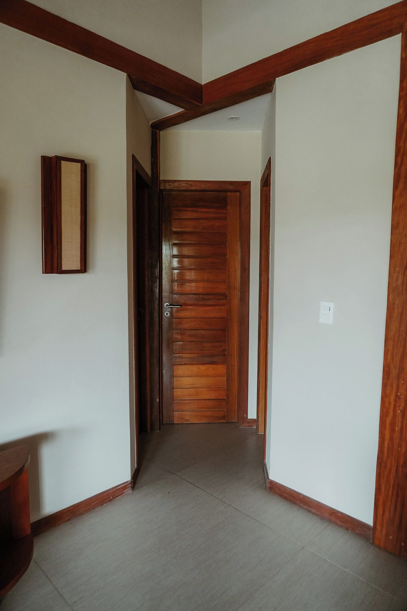 Un pasillo con puertas de madera y un cuadro en la pared.