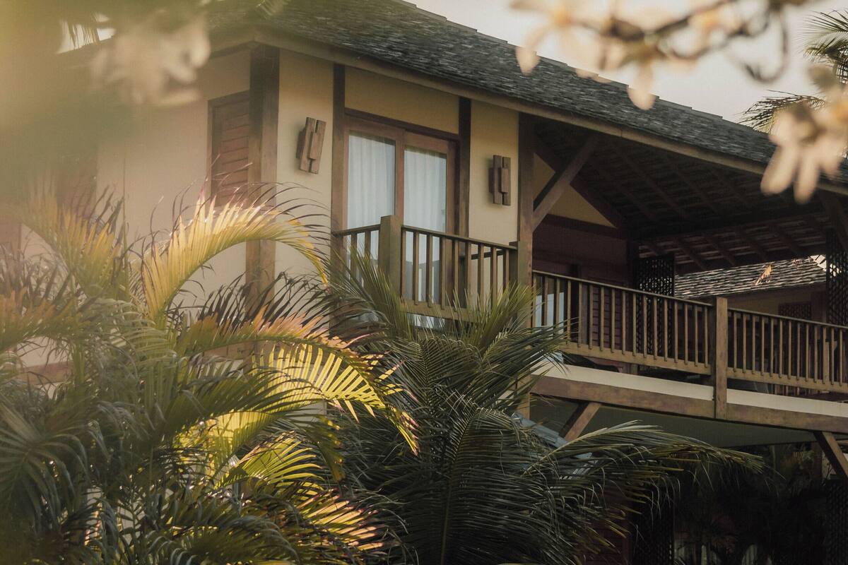 A two-story building with a balcony and a covered patio area.