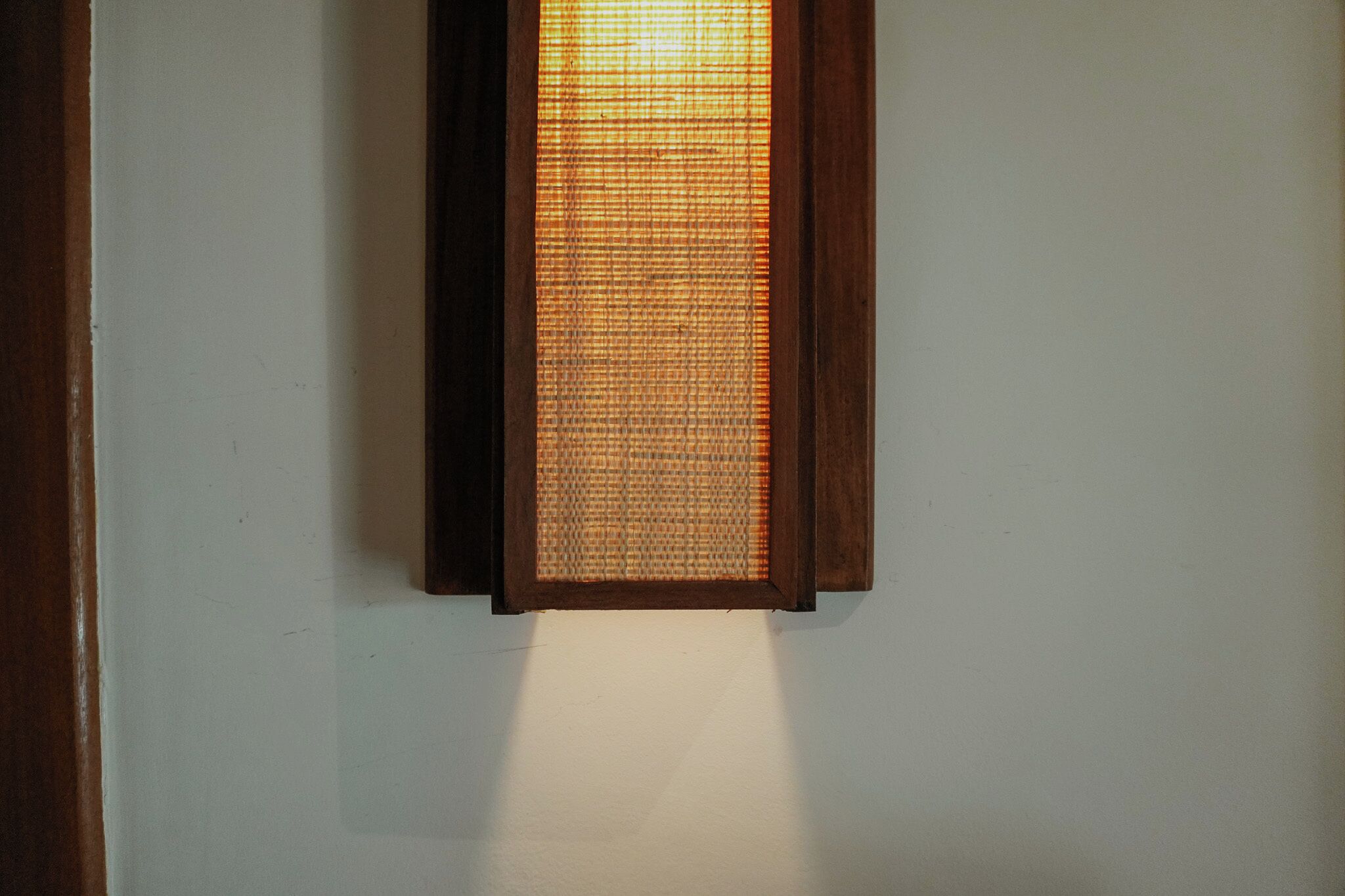 Un luminaire mural doté d’un panneau en verre texturé.