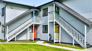 A two-story building with external staircases leading to balconies. - Fishy-Fishy Townhome, 2BR/2BA (Kenai)