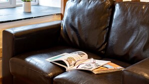 A leather sofa with a magazine and glasses on it. - Stable Cottage (Port Isaac)