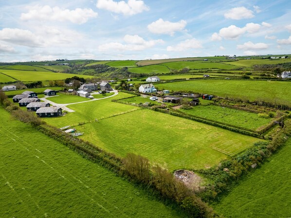 A rural landscape with houses, green fields, and a winding road.