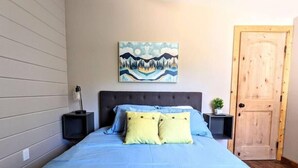 A bedroom with a large bed, a nightstand, a wall-mounted painting, and a wooden door. - # 5. The Tipsy Turkey's Den - 1 Bedroom with Amazing Views (San Diego County)