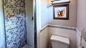 A bathroom with a shower area featuring patterned tiles, a toilet, and a framed picture on the wall. - # 5. The Tipsy Turkey's Den - 1 Bedroom with Amazing Views (San Diego County)