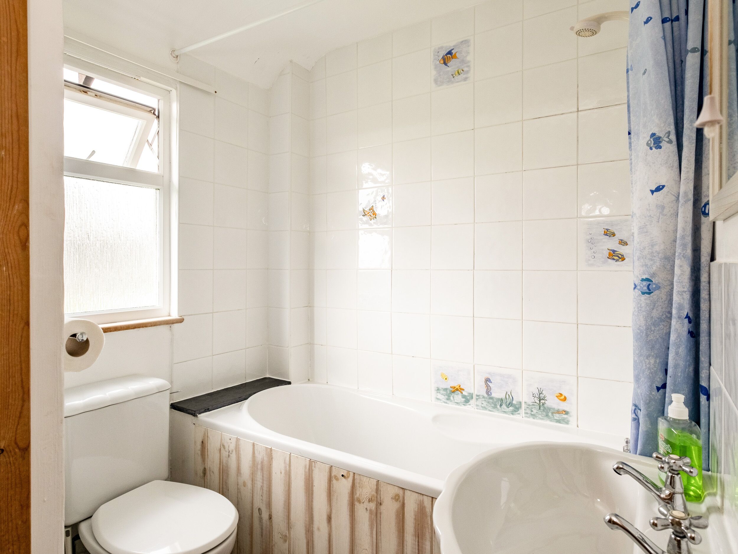 A bathroom with a toilet, a bathtub, and a sink.