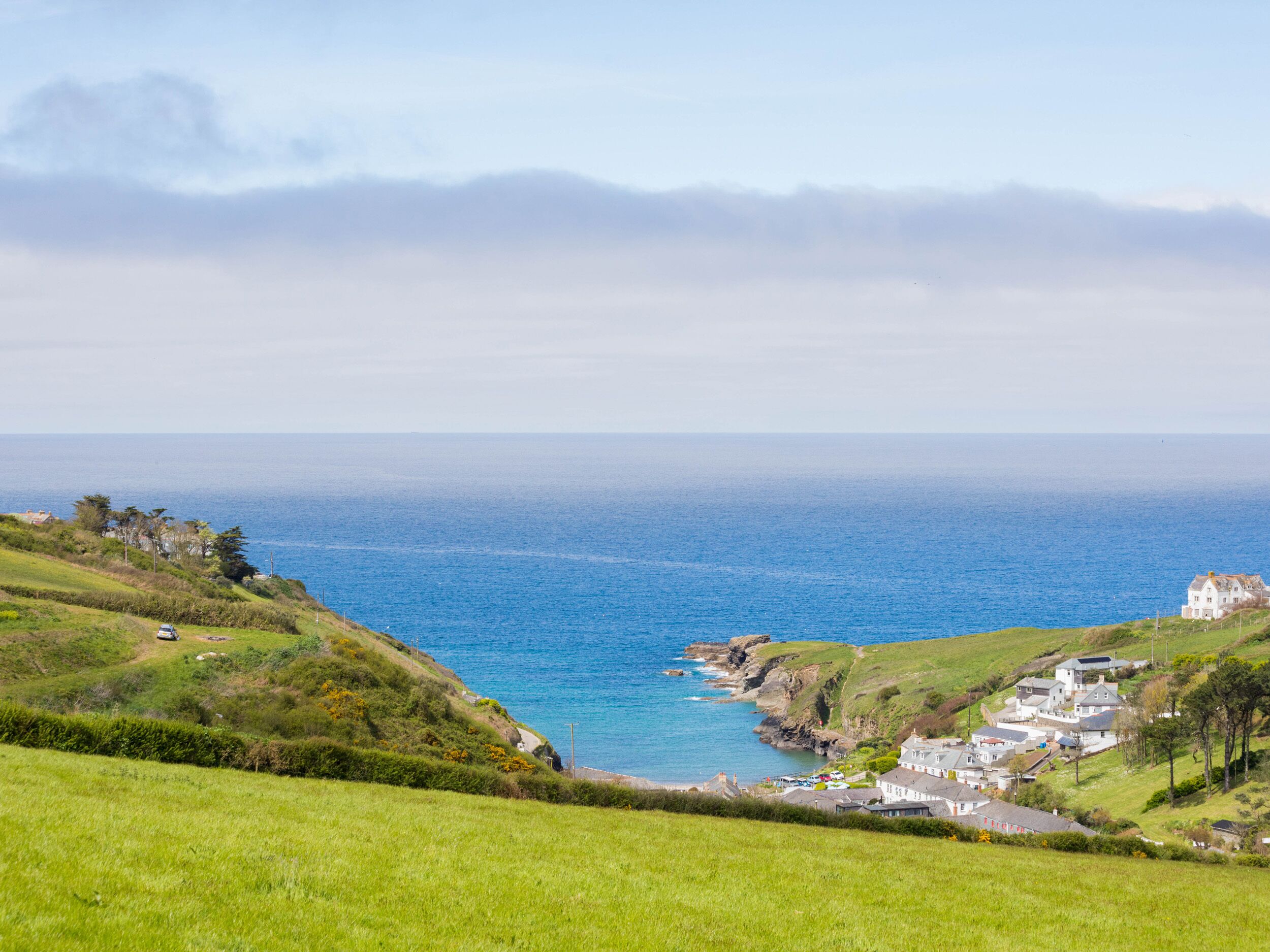 A coastal village with houses along the cliffside, overlooking the sea.