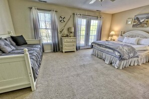 A bedroom with two beds, a dresser, and a nightstand.