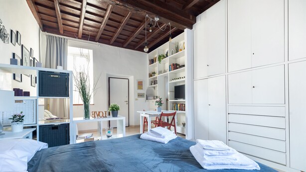 Un dormitorio con cama, escritorio y estantería.