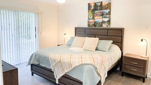A bedroom with a bed, bedside tables, a ceiling fan, and a wall-mounted artwork. - Fabulous Apartment near Disney (Kissimmee)
