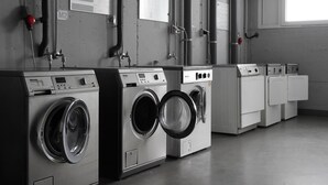 Une rangée de machines à laver de style industriel dans une laverie professionnelle.