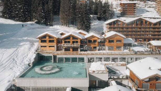 A resort with wooden cabins, a pool, and a ski slope. - Eringer Hotel (Heremence)